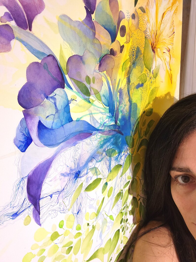 Abstract watercolor painting with a vibrant mix of blue, purple, yellow, and green hues. The painting features a large, central flower-like shape with delicate lines and overlapping layers of color.