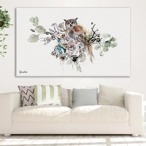 Puede incluir: Una pintura de acuarela de un b&uacute;ho posado en una rama con hojas verdes. El b&uacute;ho es marr&oacute;n y blanco con ojos amarillos. La pintura tiene un fondo blanco con algunas salpicaduras de pintura azul y verde.