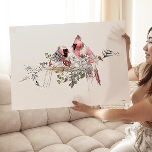 A rectangular art print featuring a detailed watercolor and ink illustration of two red cardinal birds perched on a branch. The birds are surrounded by intricate floral patterns, green leaves, and small black bird silhouettes.
