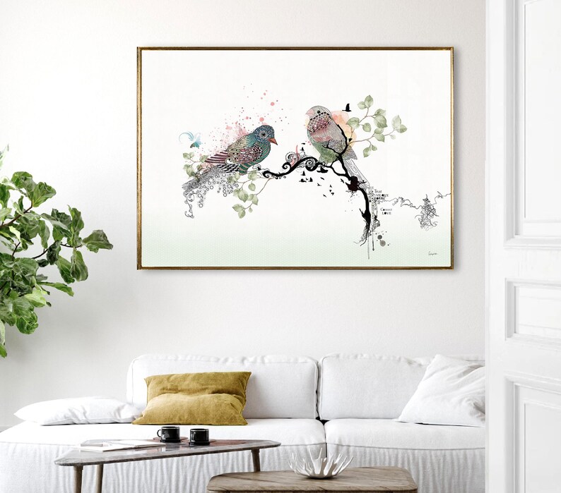 rectangular wall art print featuring two birds perched on a stylized black branch. The bird on the left has teal and pink plumage, while the bird on the right is soft pink and grey. The design includes green leaves and pink splatters.