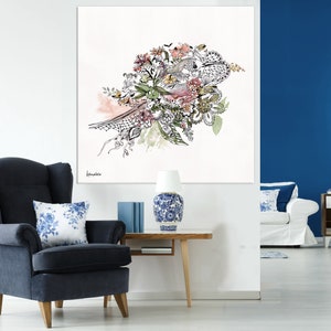 May include: A black and white floral illustration with pink, green, and yellow accents. The illustration is framed and hanging on a white wall above a blue armchair.