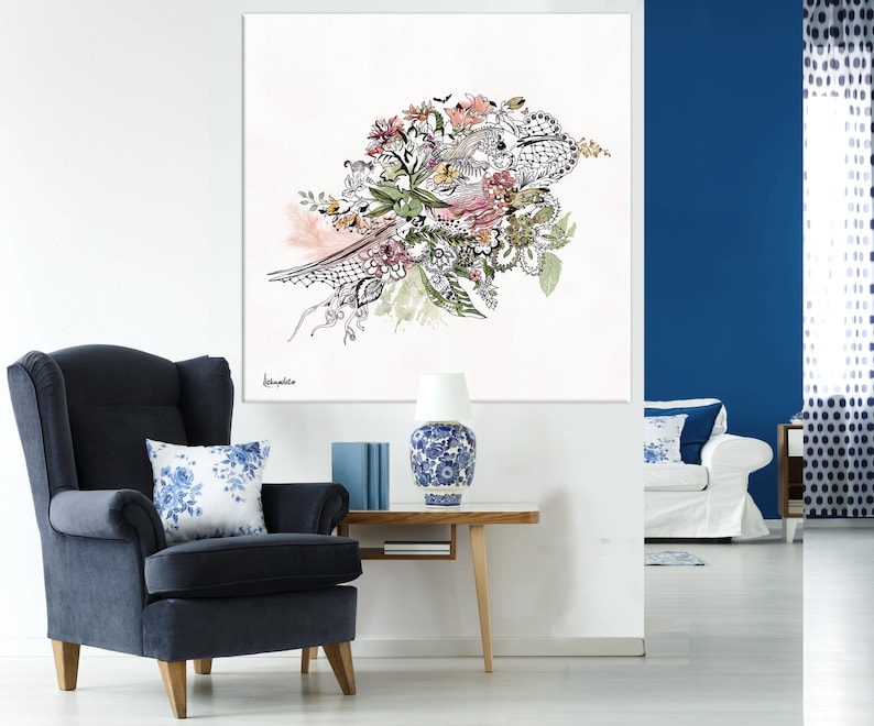 May include: A black and white floral illustration with pink, green, and yellow accents. The illustration is framed and hanging on a white wall above a blue armchair.