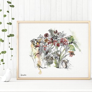 A framed watercolor print featuring an elephant adorned with a floral headdress. The artwork showcases a blend of botanical elements and animal imagery, with a soft color palette of yellows, reds, and greens. The frame is a light wood color.