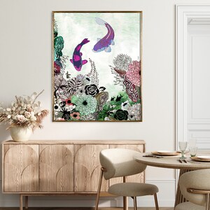 A framed print of a watercolor painting featuring two pink and purple koi fish swimming in a green and blue water with a floral background.