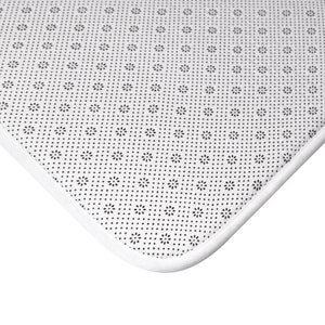 May include: Close-up of the underside of a white bath mat with a black non-slip pattern. The mat has a white border.