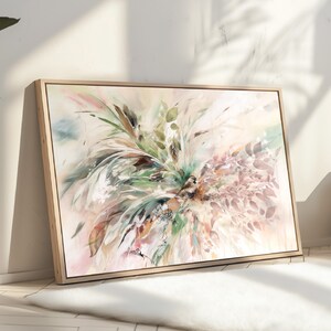 A framed abstract painting with a light background and a variety of colors including green, brown, pink, and white. The painting features a cluster of leaves and branches in a loose, organic style.
