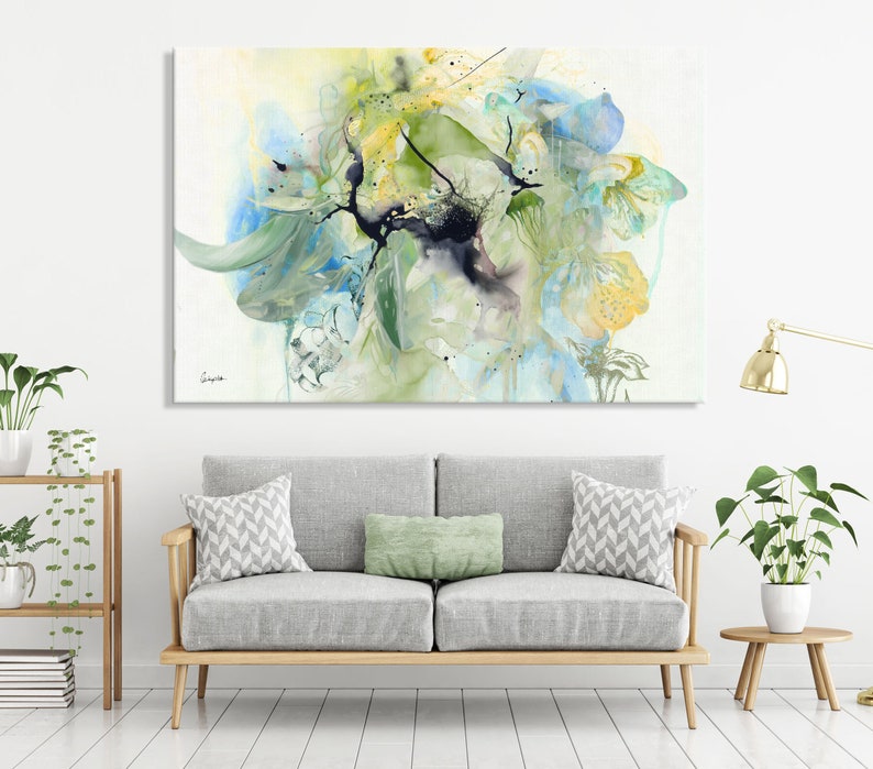 Abstract watercolor painting featuring a large, colorful floral design in shades of blue, green, and yellow. The painting has a soft, ethereal feel and is perfect for adding a touch of nature to any room.