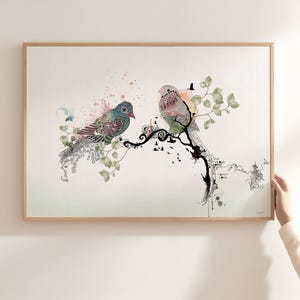 A framed wall art print featuring two stylized birds perched on a black ink-style branch. The birds are decorated with intricate patterns in shades of blue, green, and pink. Soft watercolor splashes and green leaves surround the birds.