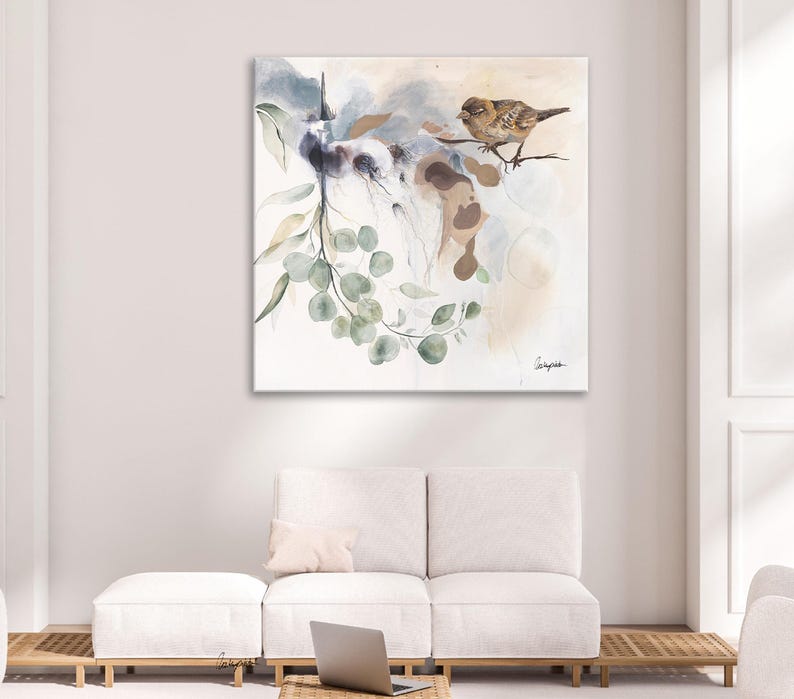 Watercolor painting of a bird perched on a branch with eucalyptus leaves. The artwork features soft, muted tones of beige, gray, and green. The bird is light brown, and the leaves are various shades of green. The background is a soft, abstract wash of colors. The painting has a calming and serene atmosphere, perfect for a living room or bedroom. The style is modern and minimalist, with a focus on natural elements.