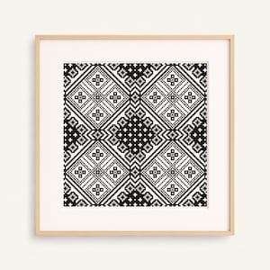 Peut inclure: Impression encadrée présentant un motif géométrique noir et blanc. Le design est composé de losanges répétés avec des motifs en forme de croix et de points. L'œuvre est encadrée dans un cadre en bois clair, pour la décoration murale.