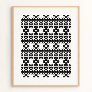 May include: A framed print featuring a repeating geometric pattern in black and white. The design consists of small squares and cross-like shapes, creating a symmetrical and intricate visual texture. The artwork is displayed in a light-colored wooden frame.