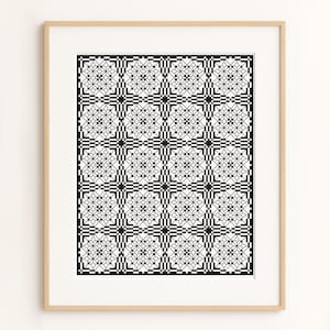 Peut inclure: Impression encadrée avec un motif géométrique noir et blanc. Le design est composé de carrés répétés avec des motifs floraux et en forme de croix. L'œuvre est dans un cadre en bois clair, pour la décoration intérieure.