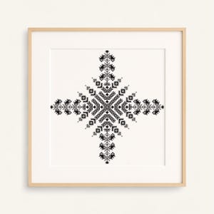 Puede incluir: Obra de arte enmarcada con un diseño geométrico simétrico en blanco y negro. La obra de arte está centrada en un fondo blanco, encerrada dentro de un marco de madera marrón claro. El diseño se asemeja a una cruz o estrella, con patrones intrincados.