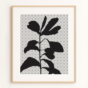May include: Framed art print featuring a black botanical silhouette against a white and gray geometric pattern. The artwork is encased in a light brown wooden frame, suitable for home decor. The image showcases a minimalist design.