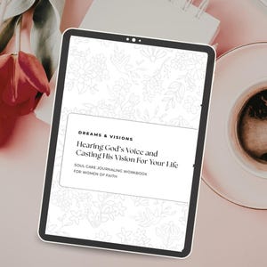 Op de afbeelding: Een digitale tablet met een werkboek getiteld "Dreams & Visions: Hearing God's Voice and Casting His Vision For Your Life." Het werkboek is voor vrouwen van geloof en bevat bloemenillustraties.