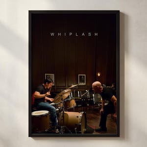 Può includere: Poster incorniciato con una scena del film "Whiplash". L'immagine mostra un batterista che suona una batteria, con un altro uomo nelle vicinanze. Il poster ha una cornice nera e la parola "WHIPLASH" è stampata in alto.