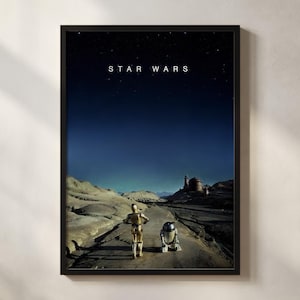 May include: A framed Star Wars poster featuring a desert landscape under a starry night sky. The image shows C-3PO and R2-D2 on a road, with the words "STAR WARS" at the top. The poster is in a black frame.