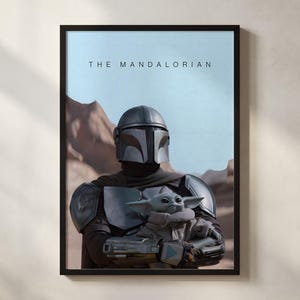May include: Framed print featuring The Mandalorian holding Grogu, also known as Baby Yoda, against a desert backdrop. The Mandalorian is in full armor, and the text "THE MANDALORIAN" is at the top. The artwork is in a black frame.