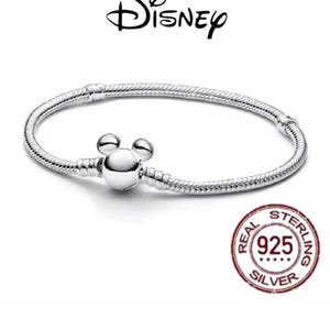 Puede incluir: Una pulsera de plata con un cierre en forma de Mickey Mouse. La pulsera tiene un dise&ntilde;o de cadena de serpiente y presenta el logotipo de Disney. Un sello rojo y blanco indica que es de plata de ley 925.