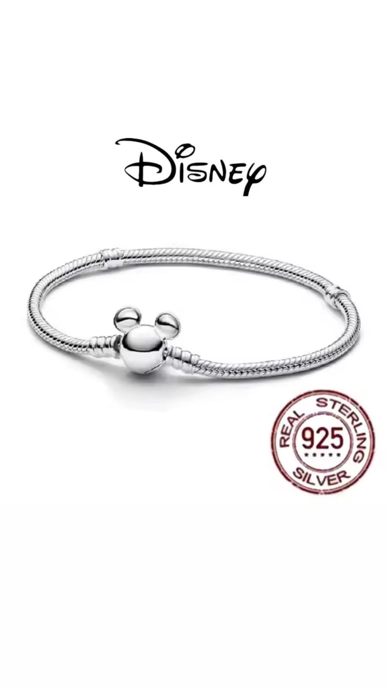 Puede incluir: Una pulsera de plata con un cierre en forma de Mickey Mouse. La pulsera tiene un dise&ntilde;o de cadena de serpiente y presenta el logotipo de Disney. Un sello rojo y blanco indica que es de plata de ley 925.