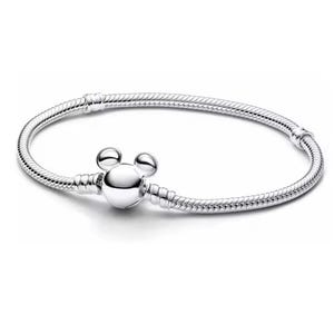 Puede incluir: Una pulsera plateada con un charm de Mickey Mouse. La pulsera tiene un dise&ntilde;o de cadena de serpiente y un cierre redondo. El charm es una representaci&oacute;n estilizada de la cabeza de Mickey Mouse. Longitud: aprox. 18 cm.
