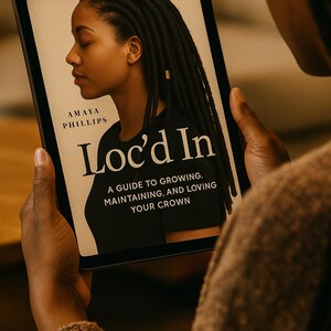 May include: A tablet showing the book cover of "Loc'd In" by Amaya Phillips. The cover features a side profile of a person with locs. The book's subtitle reads: "A Guide to Growing, Maintaining, and Loving Your Crown."