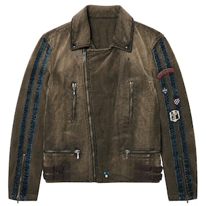 May include: A brown distressed jacket with an asymmetrical front zip, multiple zipped pockets, and dark blue vertical stripes on the sleeves. The left sleeve features several small embroidered patches, including one with the text SOUVENIR.