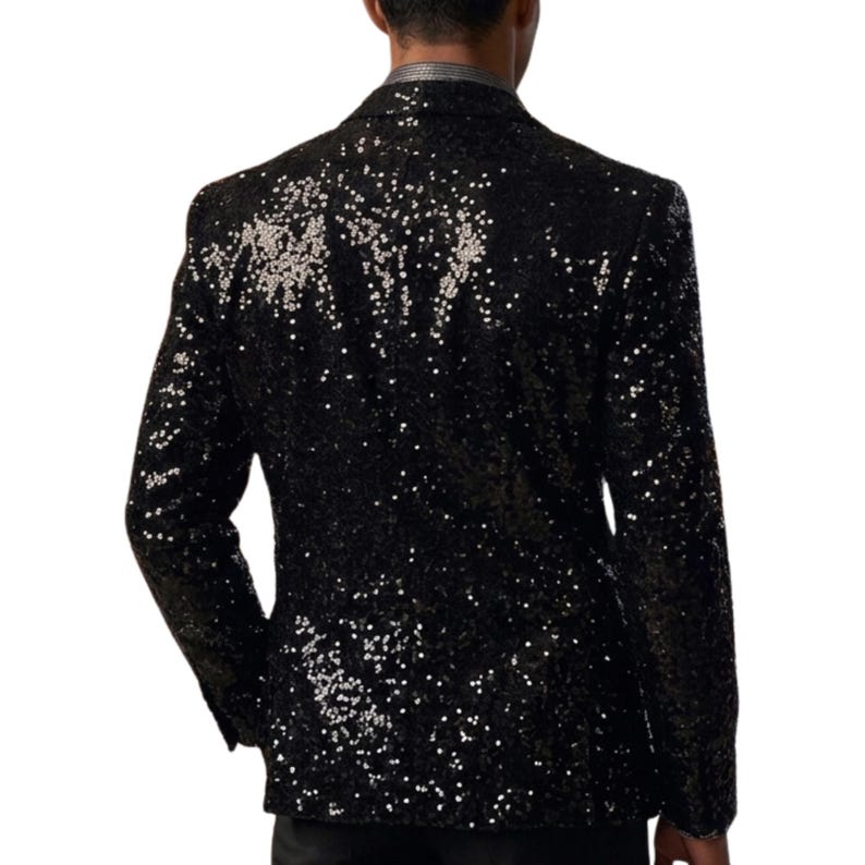 Pode incluir: Um blazer preto com lantejoulas e lapela cl&aacute;ssica. O casaco &eacute; coberto por pequenas lantejoulas refletoras que captam a luz. O blazer tem um corte sob medida e mangas compridas, adequado para eventos formais.
