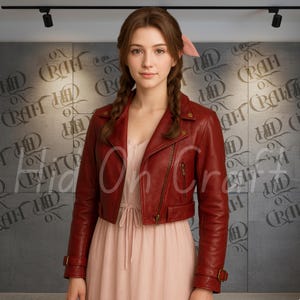 Puede incluir: Una chaqueta corta de cuero rojo con cierre de cremallera y detalles de hebilla. La chaqueta se lleva sobre un vestido rosa claro. El fondo presenta una pared gris con el texto "On Craft HD".