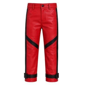 May include: Bright red pants featuring a smooth finish, a black button closure at the waist, and vertical black side stripes. The legs include diagonal black panels above the knees and adjustable black buckled straps at the bottom cuffs.