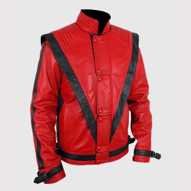 May include: A bright red leather jacket featuring bold black V-shaped panels across the chest and back. The jacket includes a high stand-up collar, ribbed shoulder detailing, a central button-down placket, and black buckled straps at the cuffs.