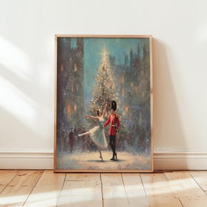 May include: A framed print depicts a winter scene with a ballerina and a soldier in front of a Christmas tree. The ballerina wears a light blue dress, and the soldier is in a red uniform. The background features a snowy cityscape.