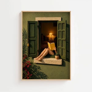 May include: A framed wall art print depicting an olive green exterior wall with an open window featuring dark green shutters. A person sits on the stone sill reading a yellow book. A small potted plant sits nearby, and red flowers grow below.