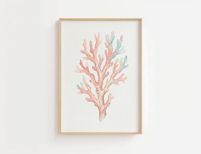 May include: A framed wall art print featuring a watercolor illustration of a branching coral structure. The coral is rendered in soft shades of peach, coral pink, and pale seafoam green, set against a plain white background within a light wood frame.