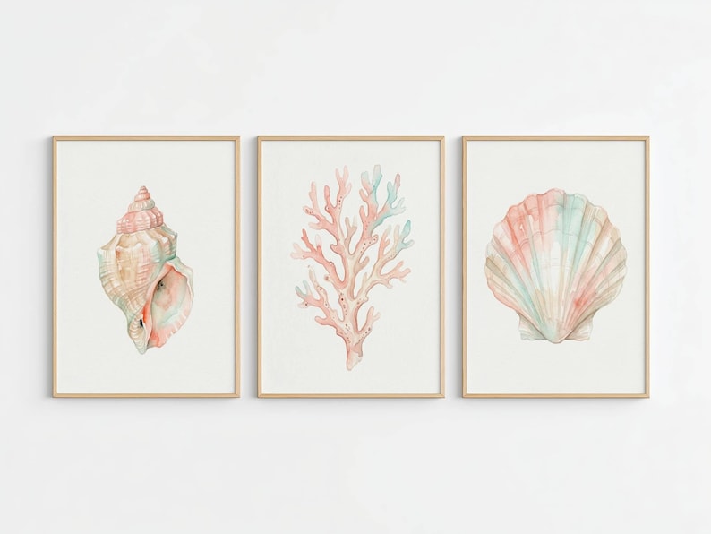 May include: A set of three framed wall art prints featuring watercolor illustrations of marine life. The left print shows a spiral seashell, the center print displays a branching coral, and the right print depicts a fan-shaped scallop shell.