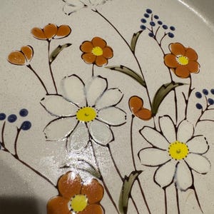 Könnte beinhalten: Eine weiße Keramik-Tasse mit schwarzem Henkel und dem Text "But First, Coffee" in schwarzer, handschriftlicher Schrift. Die Tasse steht auf einer weißen Oberfläche.