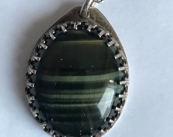 My mother’s beautiful pendent necklace:  luminous dark green gemstone with lighter green and brown stripes