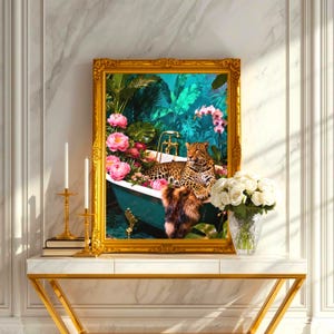 May include: A framed artwork featuring a leopard relaxing in a teal bathtub filled with flowers. The artwork has a gold ornate frame and is displayed on a white and gold console table. A vase of white roses and candles are also on the table.