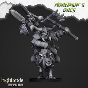 Puede incluir: Figura en miniatura detallada de un guerrero orco montado en un jabalí, con el texto "MOREDHUN'S ORCS" y "highlands miniatures". El orco está blindado y empuña armas. El jabalí tiene armadura y una silla. La figura es gris y sobre un fondo oscuro.