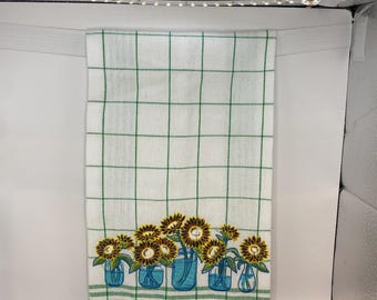 Tarro de girasoles sobre paño de cocina a cuadros verdes (40,6 x 63,5 cm)