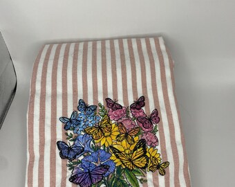 Ramo de flores con mariposas revoloteando sobre una toalla de rayas rosa (48 x 73 cm)