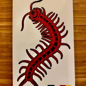 May include: A red and black illustration of a centipede on a white background. The centipede is stylized with segmented body and numerous legs. Small graphic icons are at the bottom.