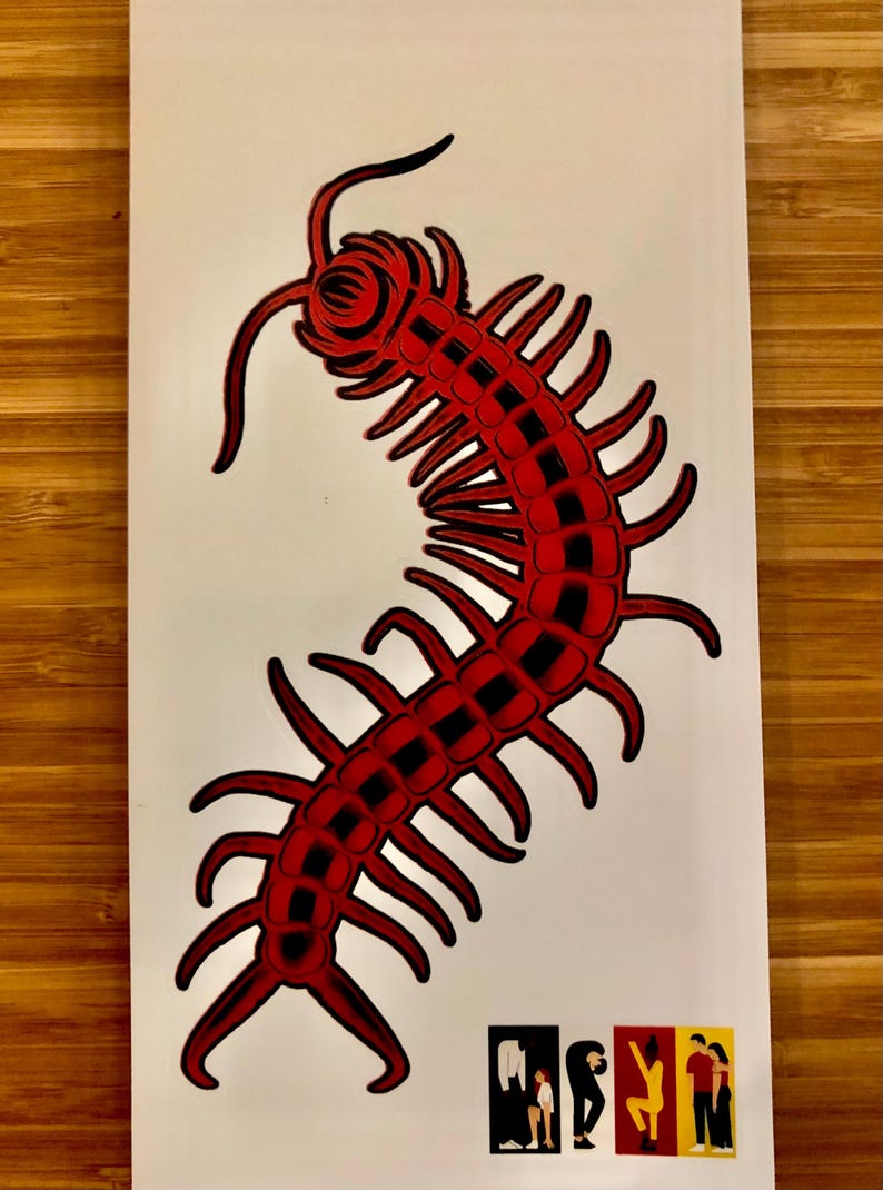 May include: A red and black illustration of a centipede on a white background. The centipede is stylized with segmented body and numerous legs. Small graphic icons are at the bottom.