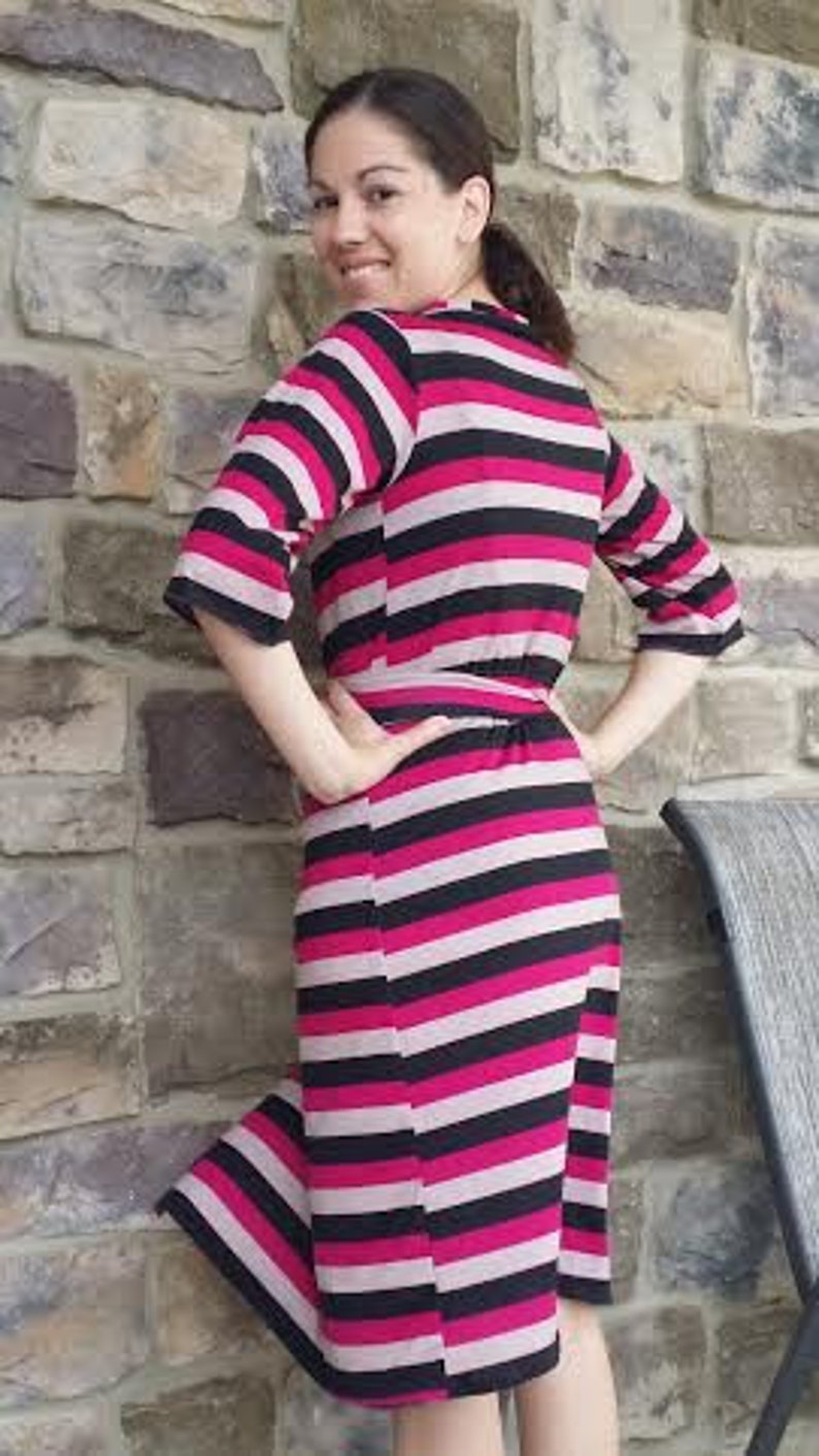 May include: A pink and black striped midi dress with a wrap style and a tie belt. The dress is made of a soft, stretchy fabric.