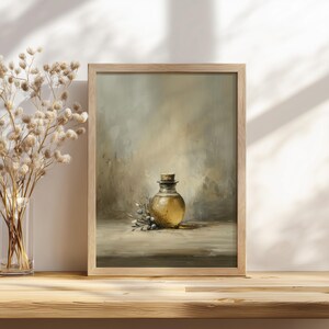May include: A framed print of a still life painting featuring a round glass bottle with a cork stopper. The bottle is filled with a golden liquid and is surrounded by sprigs of greenery. The artwork has a neutral color palette.