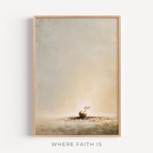 May include: A framed art print featuring a serene, abstract landscape in muted tones of beige, brown, and light blue. A small, round object with a sprig of leaves sits on a textured surface. The text "WHERE FAITH IS" is at the bottom.