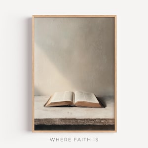 May include: A framed print featuring an open book with aged, yellowed pages. The book rests on a weathered, light-colored surface against a neutral wall. The text "WHERE FAITH IS" is at the bottom.