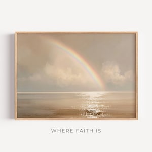 Puede incluir: Una impresión artística enmarcada que presenta un arcoíris sobre una extensión de agua tranquila bajo un cielo nublado. La obra de arte tiene una paleta de colores apagados con el texto "WHERE FAITH IS" en la parte inferior.