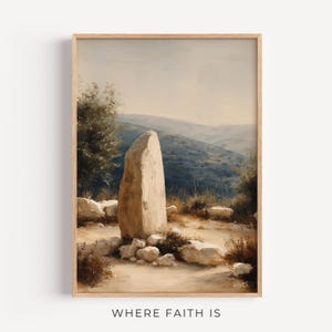 Könnte beinhalten: Ein gerahmter Wandkunstdruck, der einen hohen, hellen stehenden Stein in einer Wüstenlandschaft mit sanften Hügeln im Hintergrund, trockenem Gestrüpp und verstreuten Felsen zeigt, mit dem Text WHERE FAITH IS am unteren Rand des Rahmens.