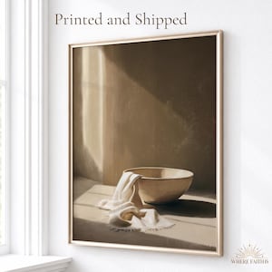 May include: A framed wall art print featuring a beige ceramic bowl and a draped white cloth on a surface. The artwork displays a warm, neutral color palette with soft light and shadows. The text "Printed and Shipped" appears at the top.